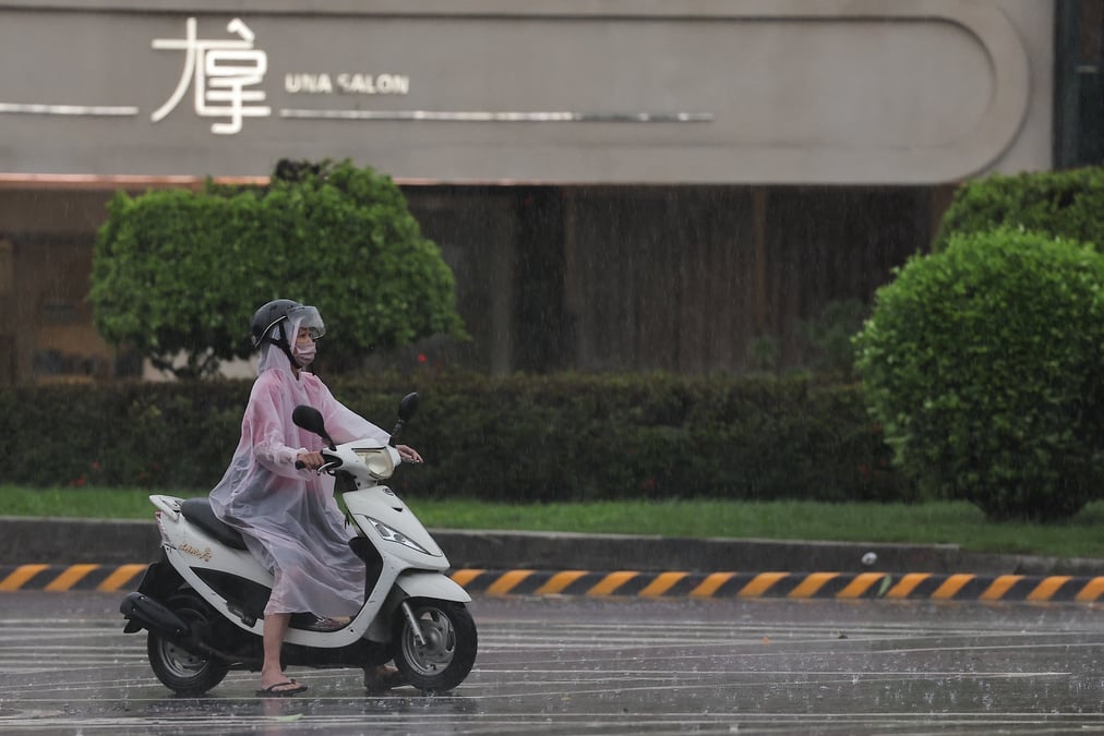 Une personne sur une motocyclette s'arrete a un signal alors que le typhon krathon approche a kaohsiung, taiwan