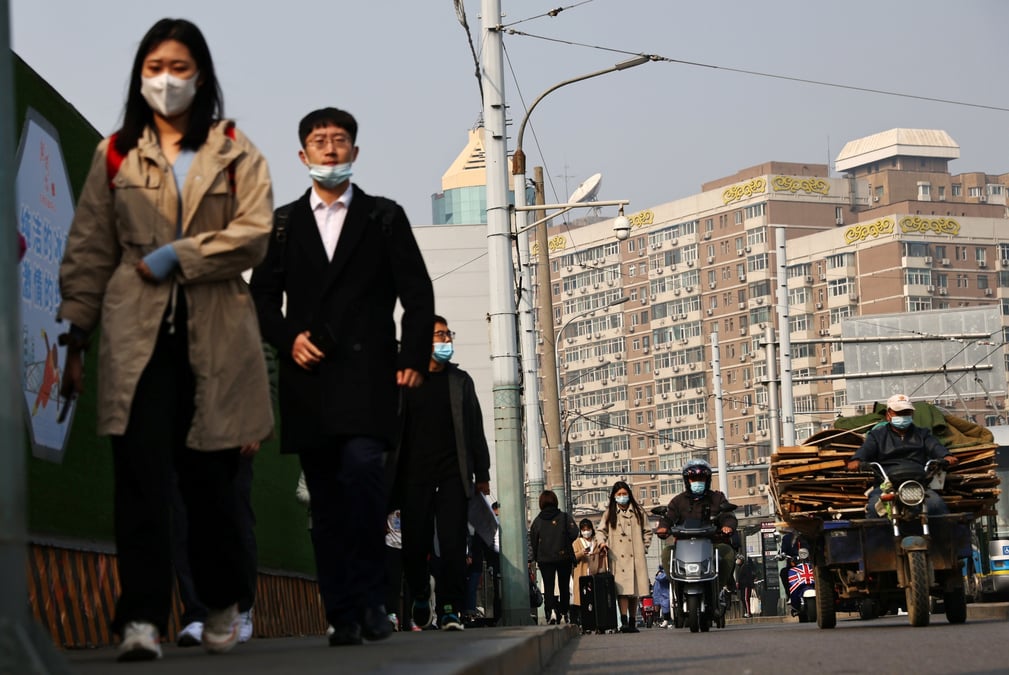 Des personnes portent des masques de protection dans une rue de pekin lors de la pandemie liee au coronavirus (covid-19) en chine