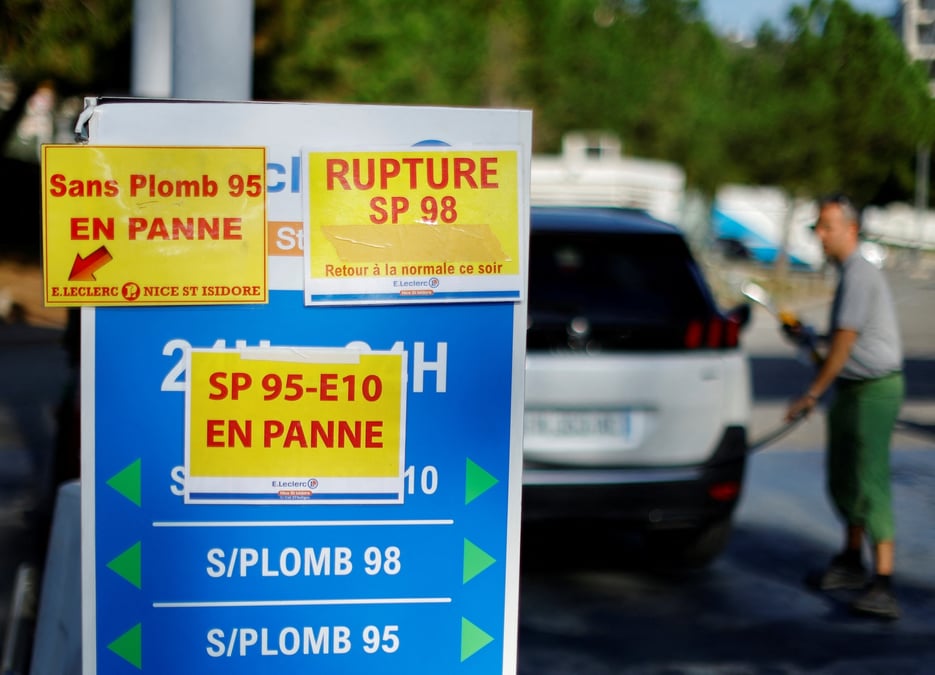 Des panneaux indiquant "panne seche" sur des pompes a essence