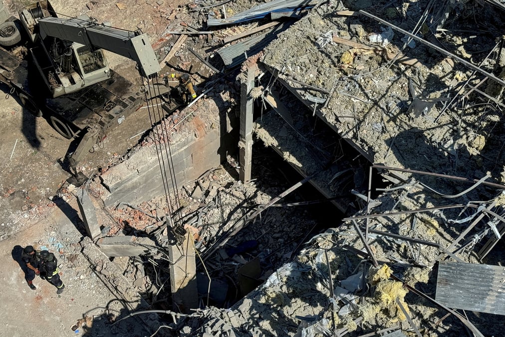Des membres des services d'urgence se tiennent sur le site ou un hotel a ete touche par un missile a kramatorsk