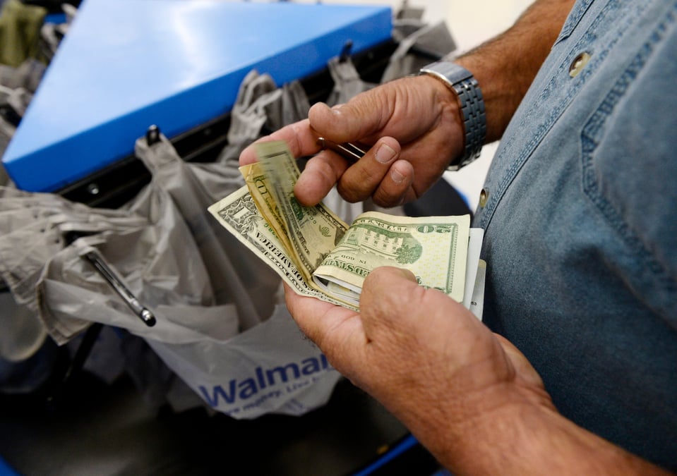 Un client compte son argent a la caisse d'un magasin walmart dans le quartier de porter ranch a los angeles.