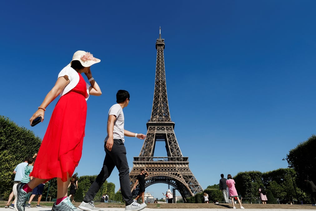 Des touristes marchent devant la tour eiffel a paris