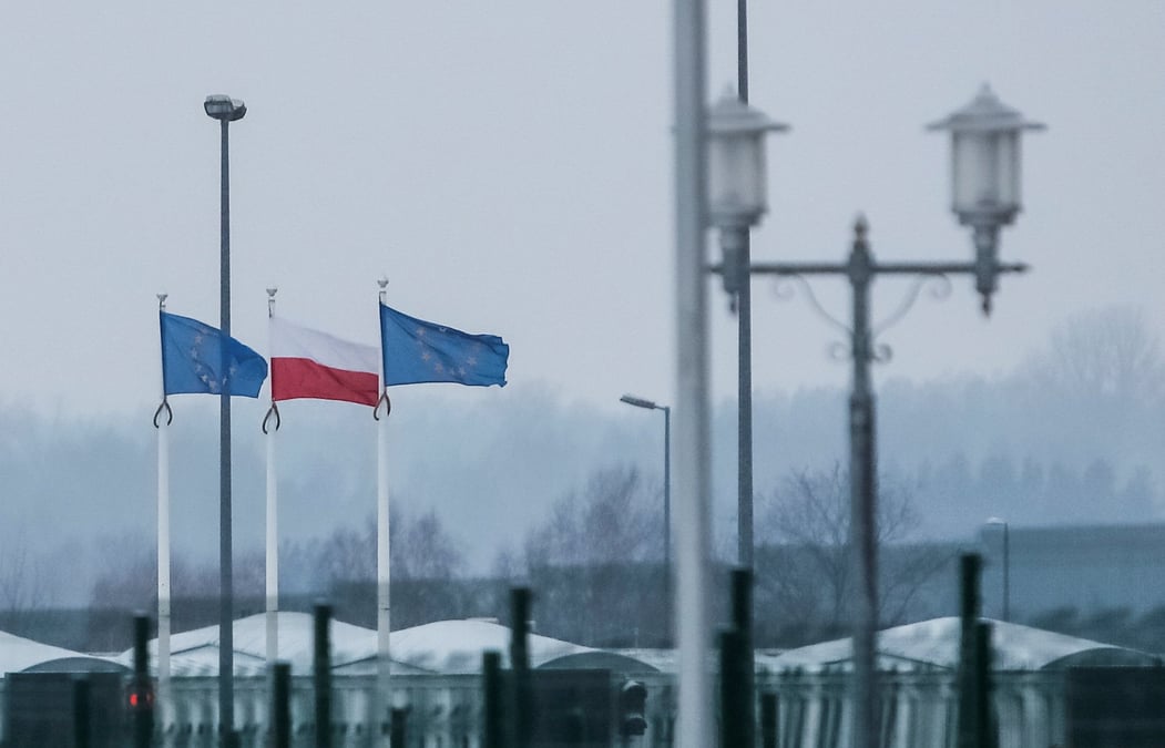 Une vue sur la frontiere bielorusse-polonaise montre des drapeaux polonais et europeens derriere une cloture