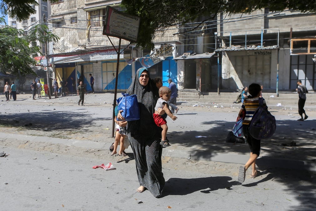 Des palestiniens marchent dans les rues de gaza lors des frappes israeliennes