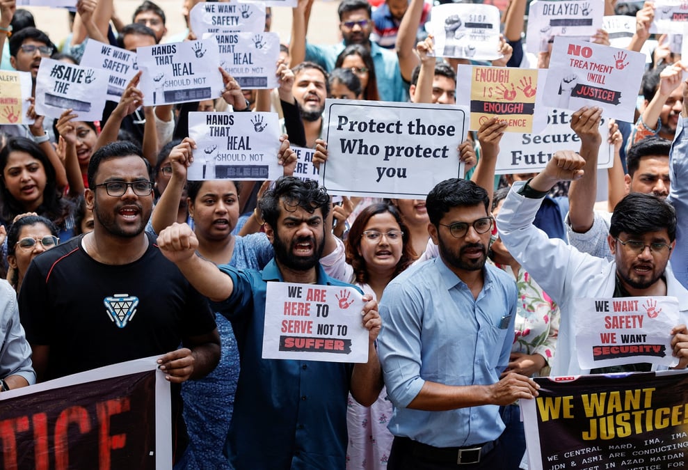 Le personnel medical crie des slogans en tenant des pancartes lors d'une manifestation dans un hopital de mumbai.