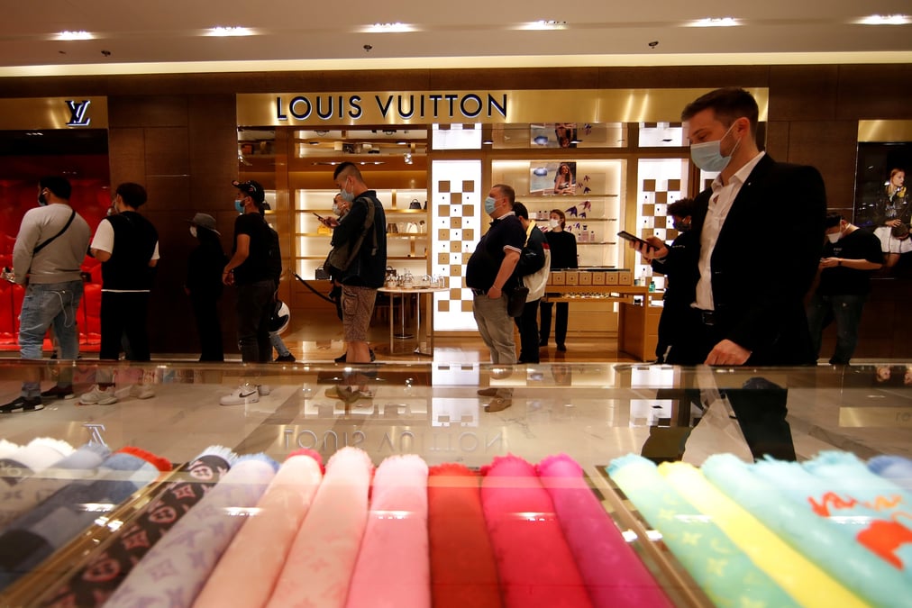 Des clients font la queue devant un magasin louis vuitton a paris