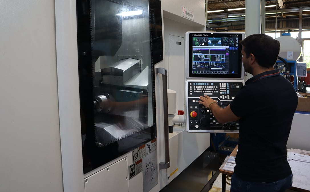 Un opérateur de Suntec Industries France manipule la machine Nakamura NTJ100 : Tour bi-broches & 10 axes pour l’usinage de moyeu et corps aluminium.
