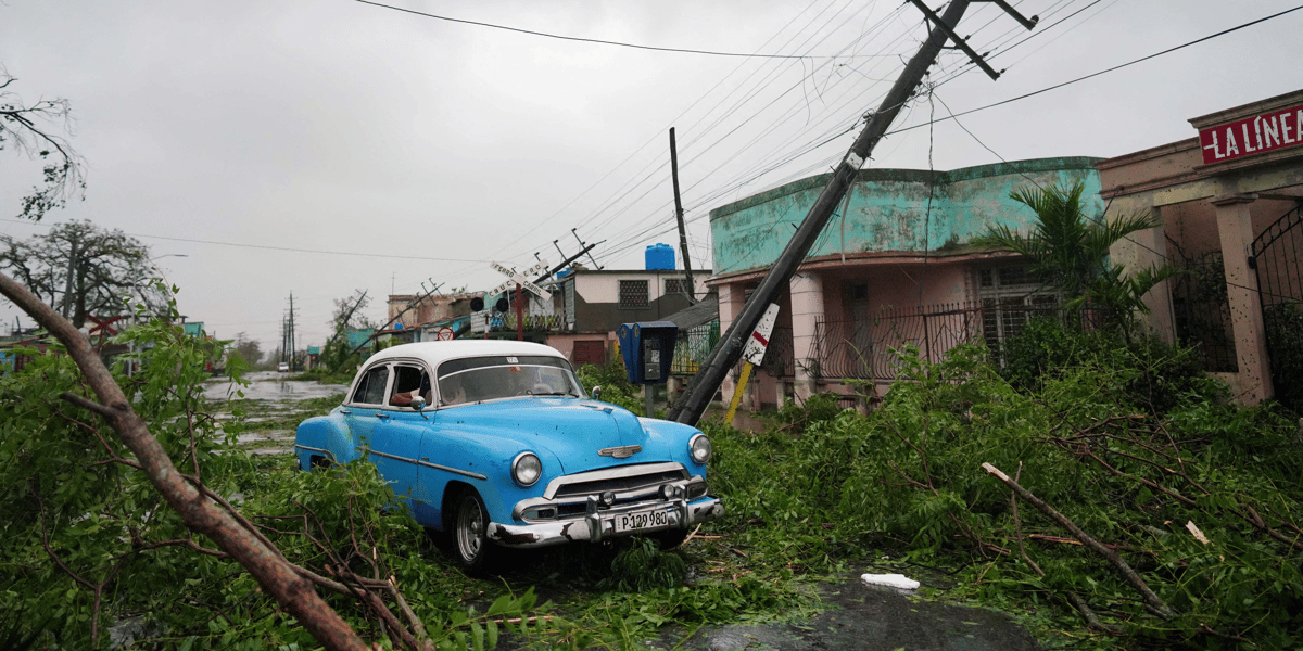 Une voiture de collection passe a cote de debris causes par l'ouragan ian lors de son passage a pinar del rio, a cuba