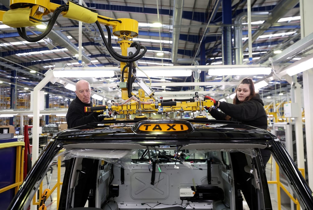 Des ouvriers montent un panneau de toit sur la ligne de production du taxi electrique tx a l'interieur de l'usine levc (london electric vehicle company) a coventry.