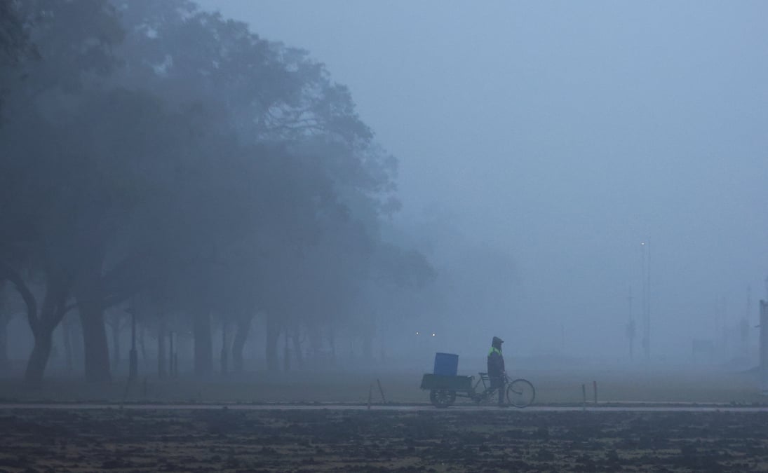 Un homme marche pres de l'india gate par une froide matinee d'hiver a new delhi
