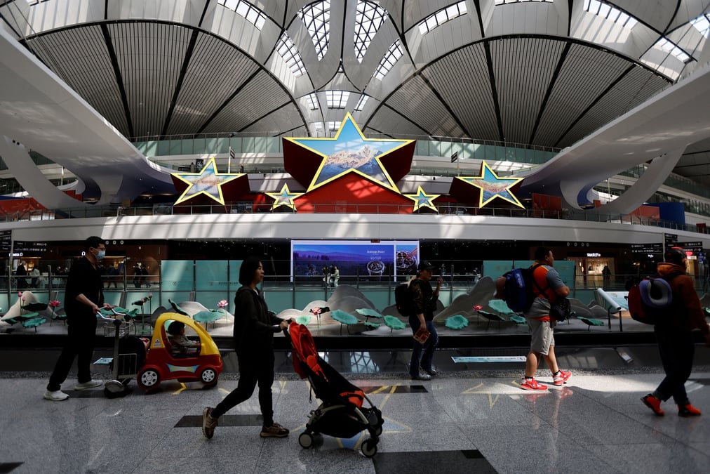 Photo d'archives des  voyageurs qui passent devant une installation en forme de cinq etoiles, a l'aeroport international de pekin daxing a pekin