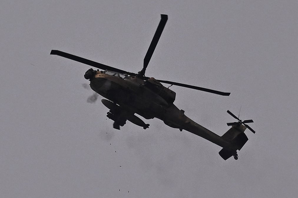 Un helicoptere d'attaque ah-64 apache de l'armee de l'air israelienne tire avec sa mitrailleuse, pres de la frontiere entre l'israel et la bande de gaza