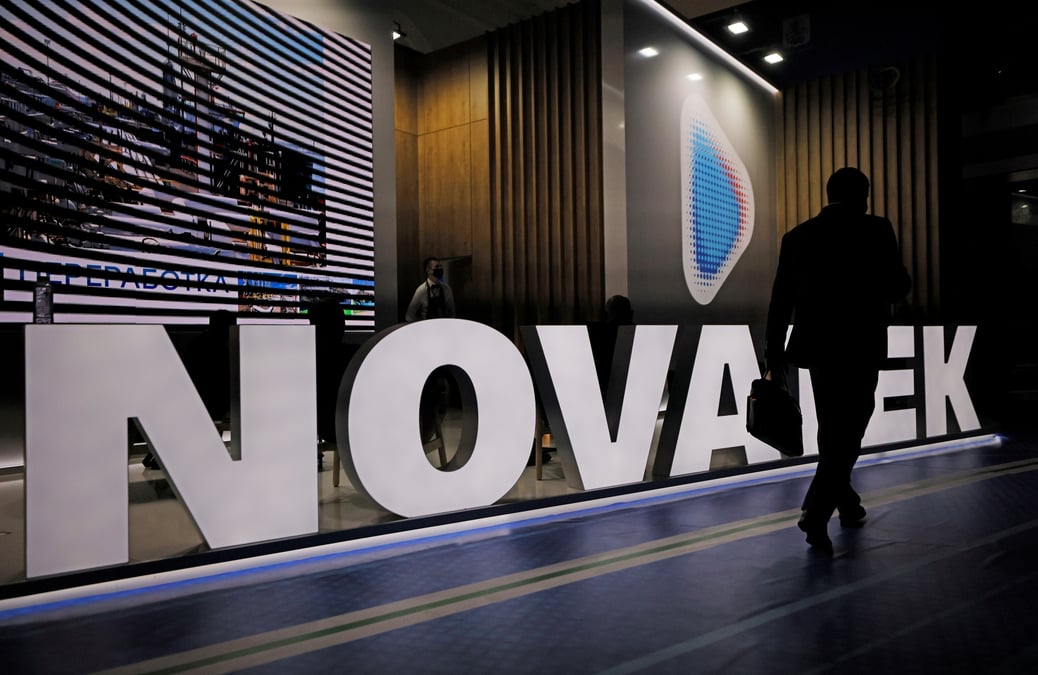 Un participant a un forum passe devant un stand du producteur de gaz russe novatek