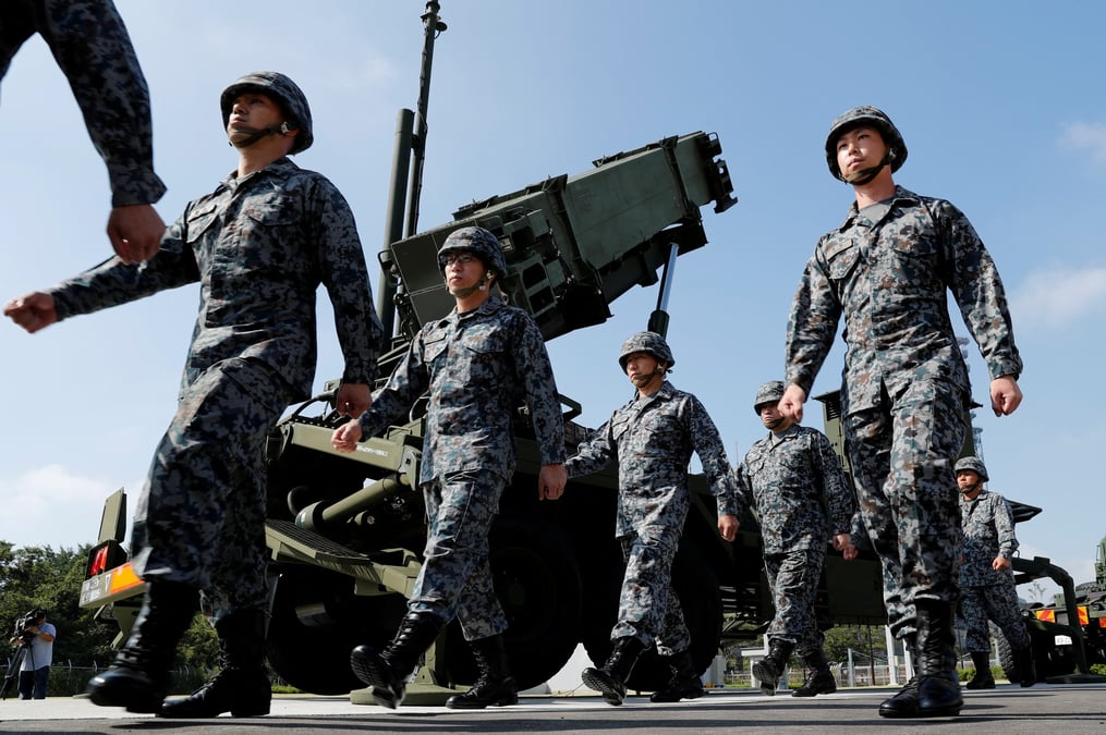Des soldats des forces japonaises d'autodefense passent devant une unite de missiles patriot advanced capability-3 (pac-3)