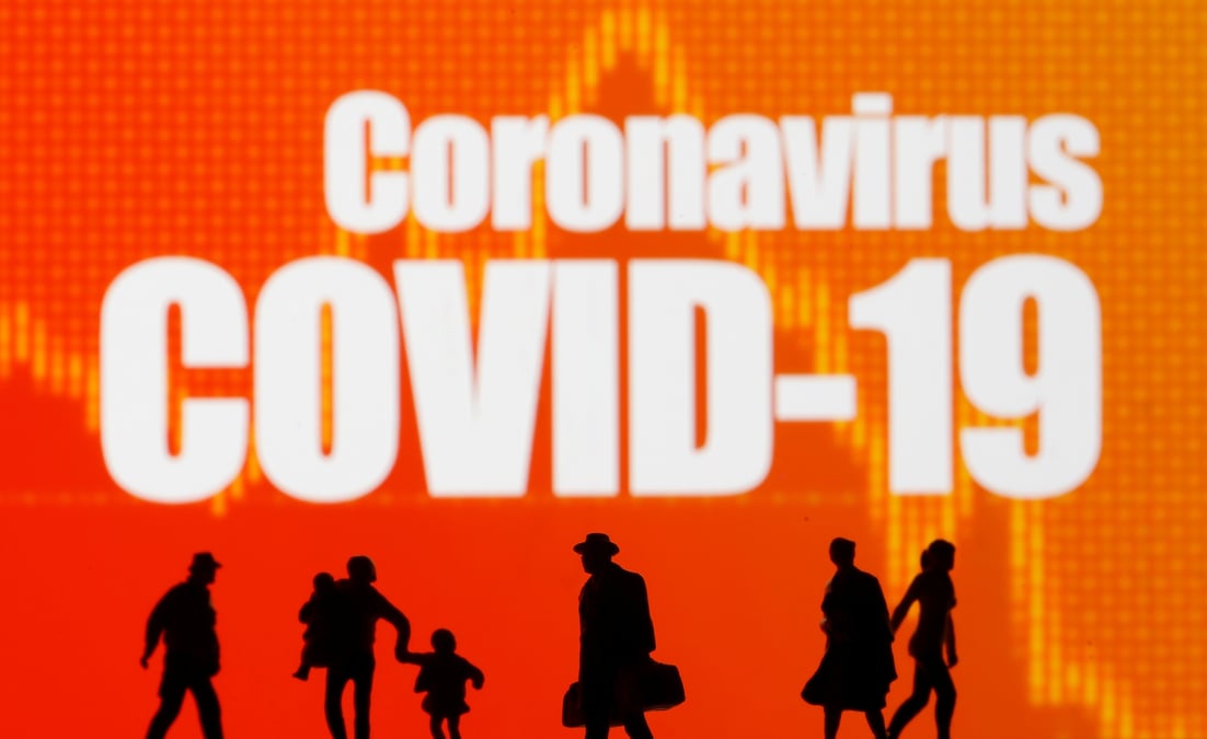 De petites figurines de jouets sont vues devant les mots coronavirus et covid-19 dans cette illustration