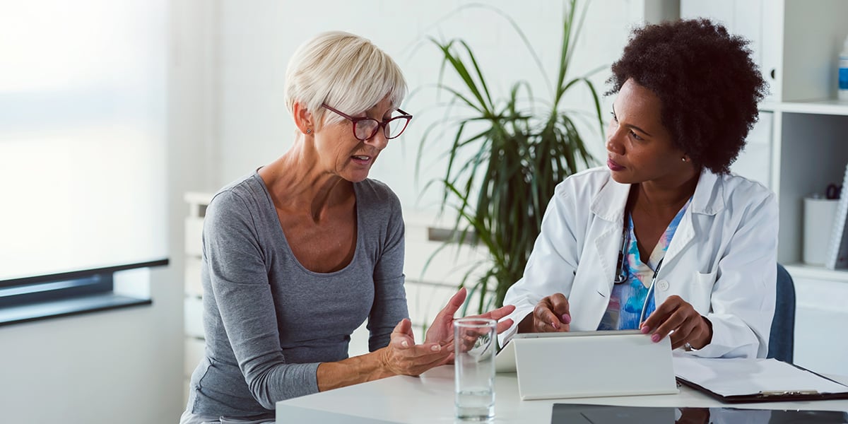 Une femme médecin avec une patiente âgée regardant les résultats de ses examens.