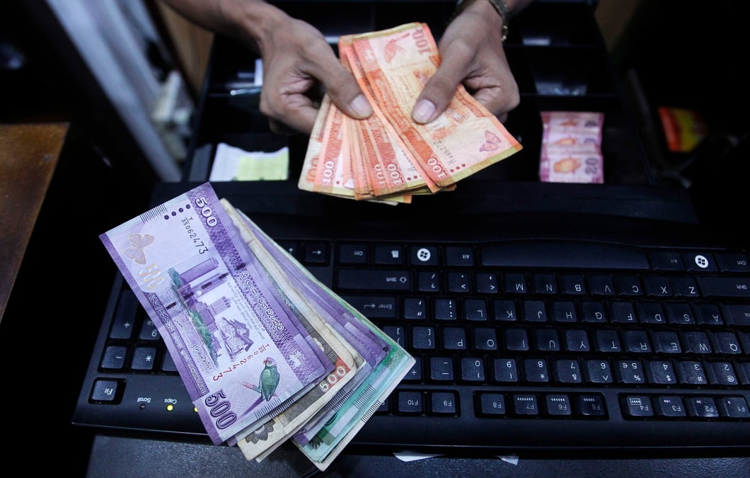Photo d'archives d'un vendeur qui prepare des billets sri-lankais pour les mettre en liasse dans un magasin de colombo.