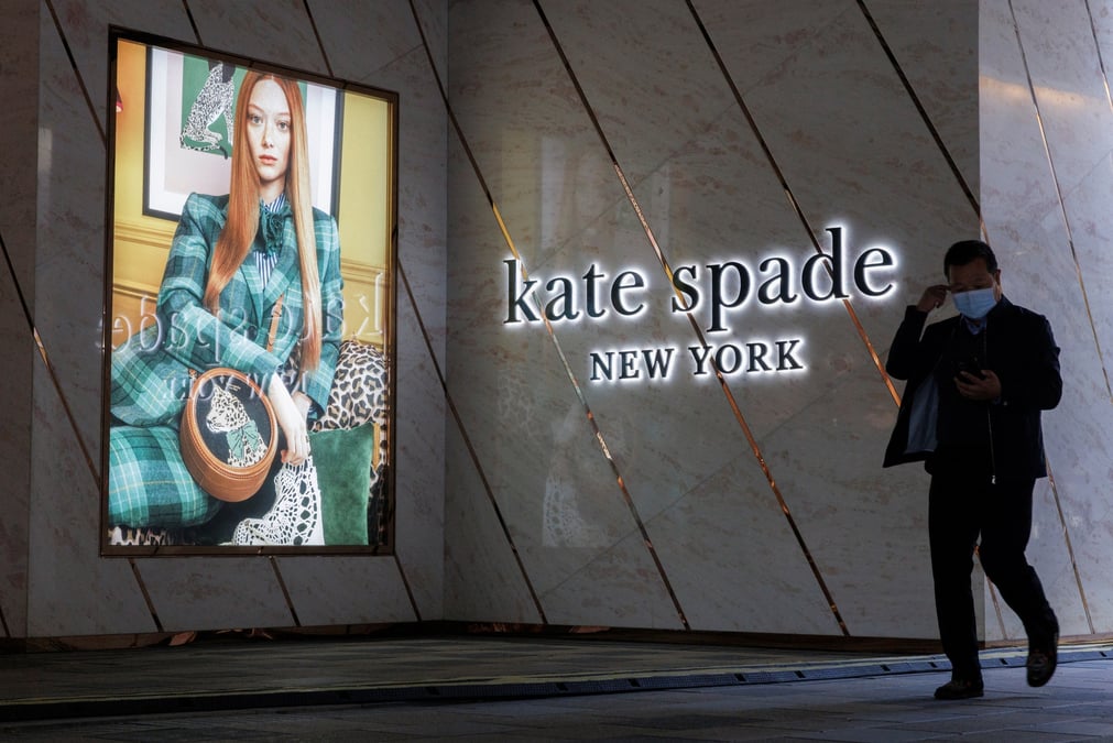 Un homme passe devant un magasin kate spade dans un quartier commercant de pekin