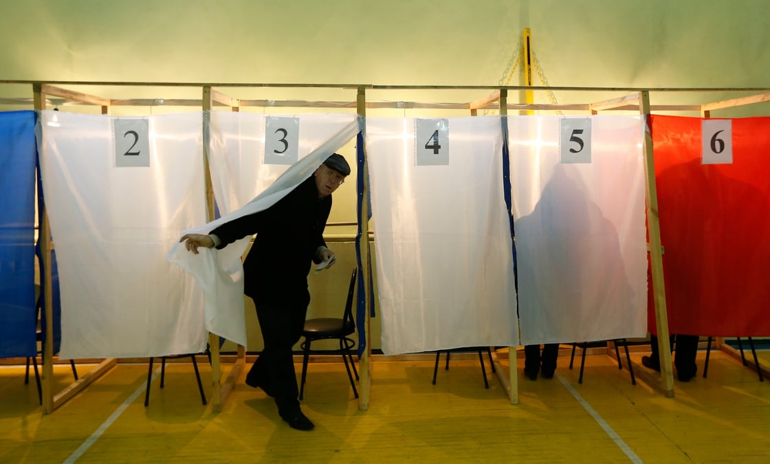 Un homme quitte un isoloir pour deposer son bulletin de vote