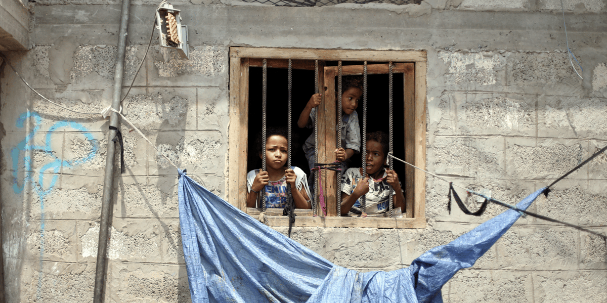 Yémen : des enfants de la communauté Muhamasheen regardent depuis la fenêtre de leur maison à Sanaa