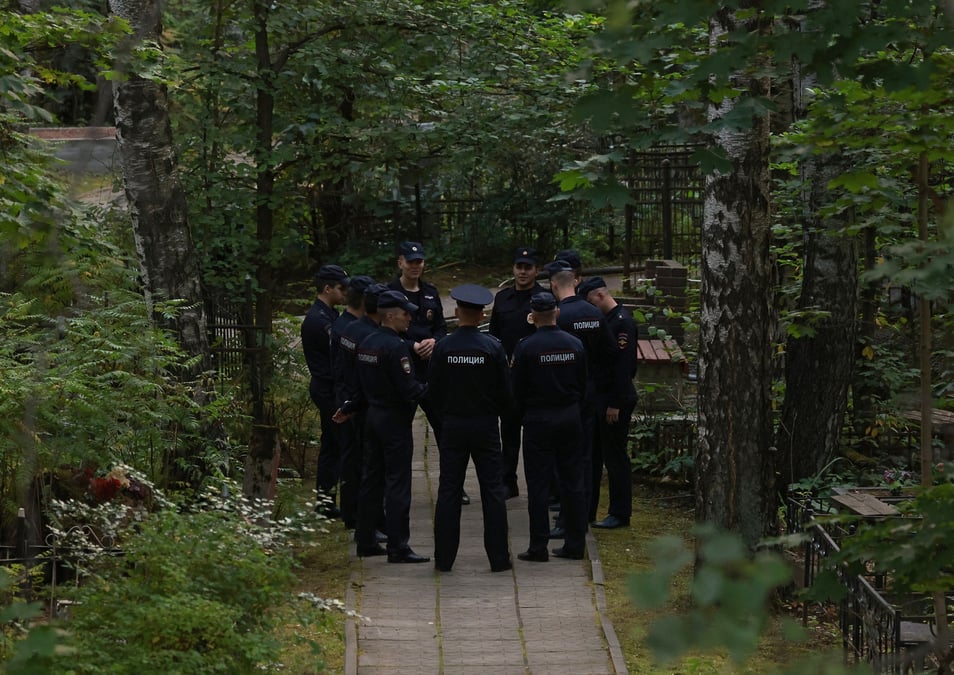 Des policiers se rassemblent pres de la tombe d'evgueni prigojine au cimetiere porokhovskoye a saint-petersbourg