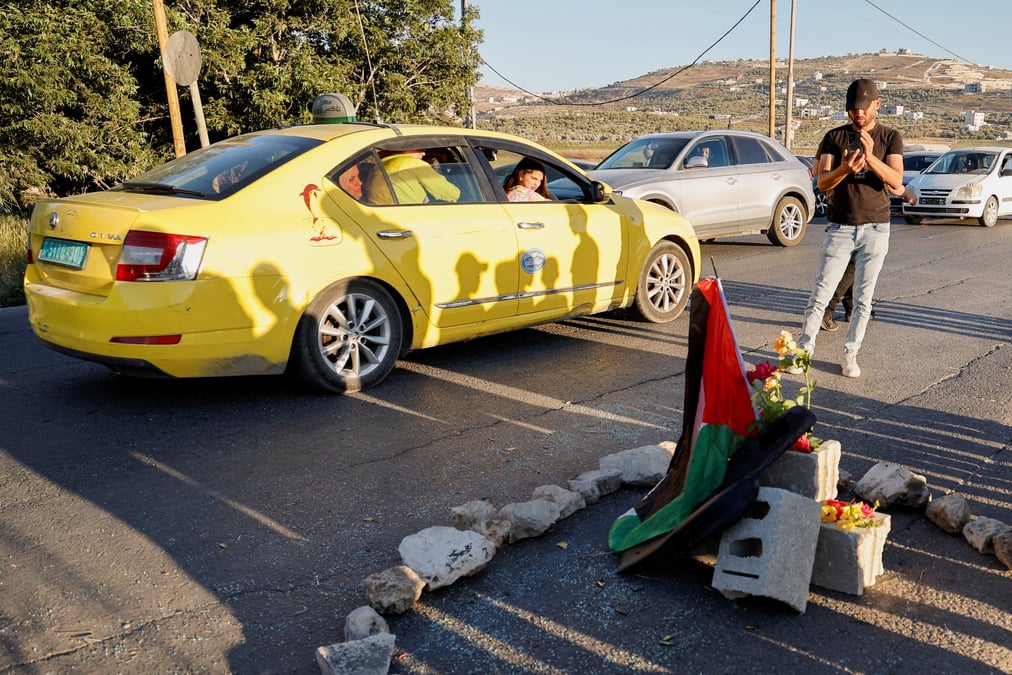 Des palestiniens se rassemblent sur les lieux ou les forces israeliennes ont pris pour cible une voiture palestinienne, pres de jenine