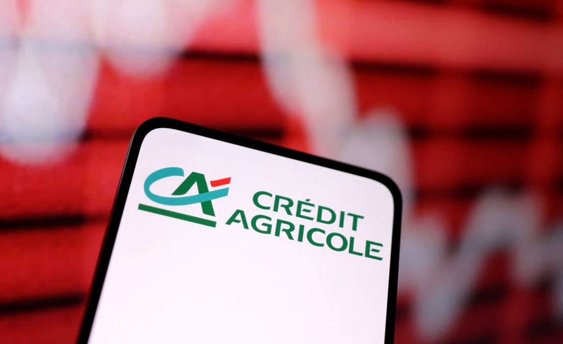 Le logo de credit agricole et un graphique boursier decroissant