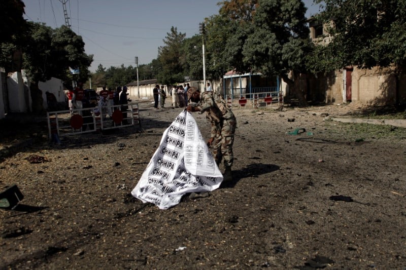 A soldier covers a body after a blast in quetta