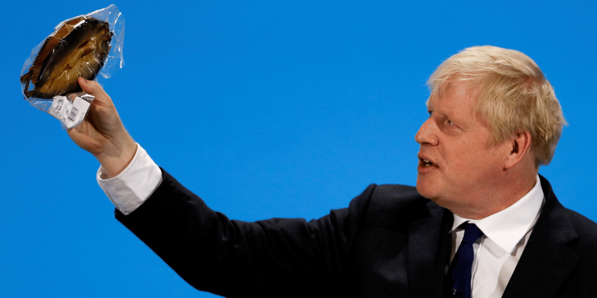 Londres, le 17 juillet 2019. Boris Johnson, alors favori pour le poste de Premier ministre, brandit un hareng fumé dans un emballage plastique pour dénoncer les "bureaucrates de Bruxelles" qui imposeraient des règles absurdes. Il sera contredit par la Commission européenne.