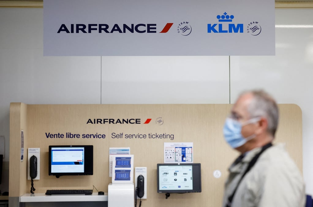 Un passager passe devant les logos air france et klm a l'aeroport de nantes-atlantique en france
