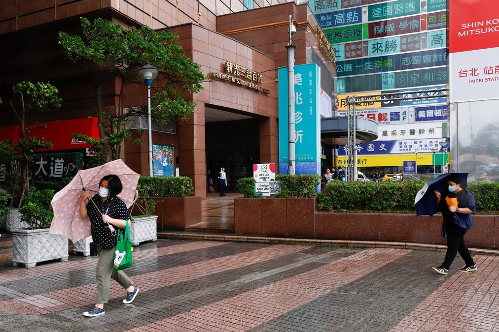 Des personnes s'abritent sous leurs parapluies dans les rue de taipei