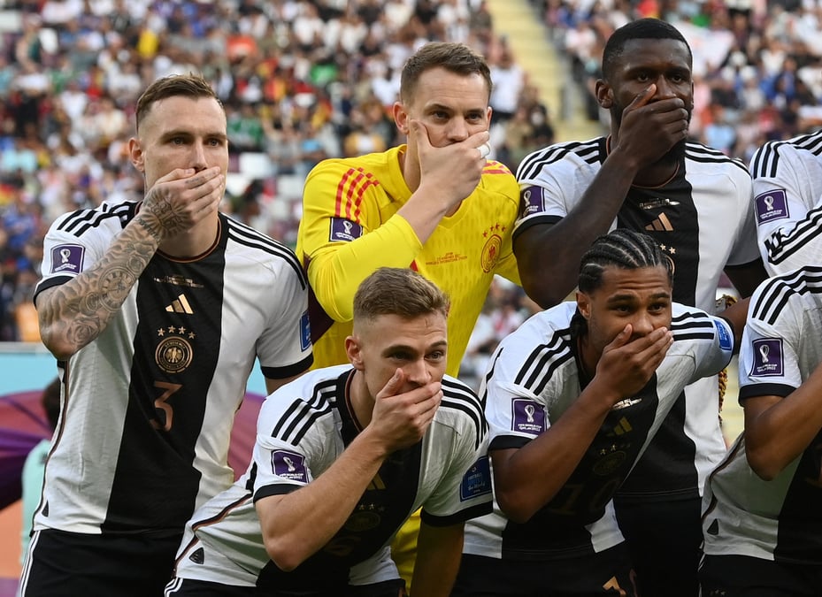 Des joueurs de football allemands se couvrent la bouche alors qu'ils posent pour une photo de groupe de l'equipe avant un match de la coupe du monde de la fifa