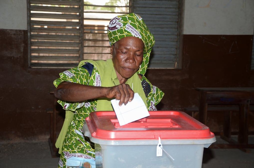 Une femme depose son bulletin dans un bureau de vote au benin