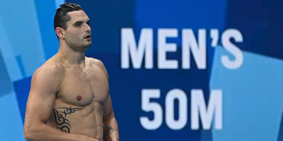 Le nageur français Florent Manaudou à Tokyo, en 2021, devant un panneau officiel des JO.