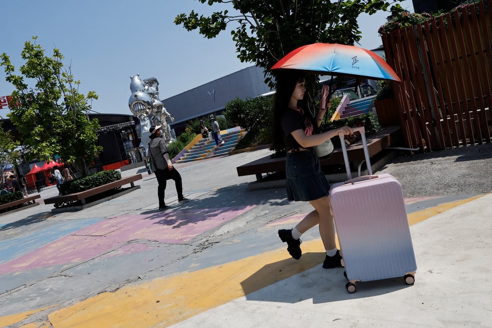 Une femme utilise un parapluie pour se proteger du soleil dans le cadre d'une alerte rouge a la canicule a pekin, en chine