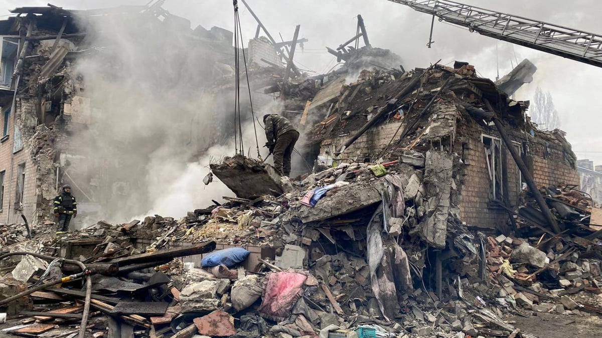 Des sauveteurs travaillent sur le site d'un batiment residentiel fortement endommage par une frappe de missile russe, dans la ville de novohrodivka