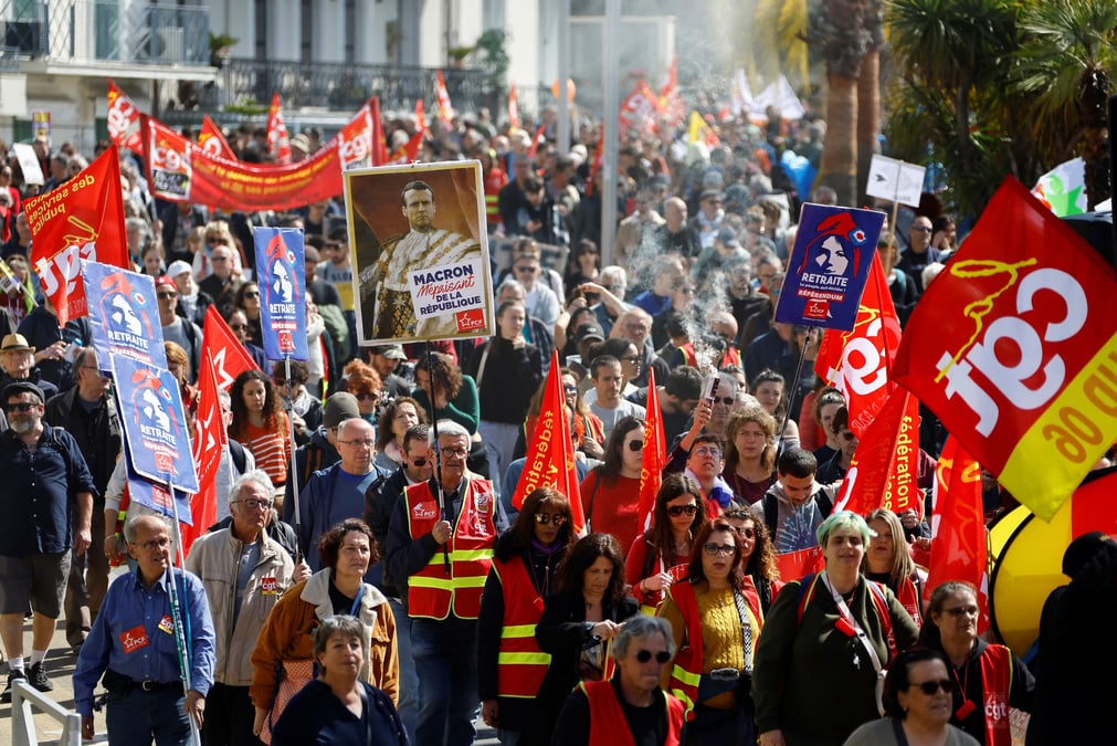Des manifestants du syndicat cgt tiennent une pancarte representant le president francais emmanuel macron