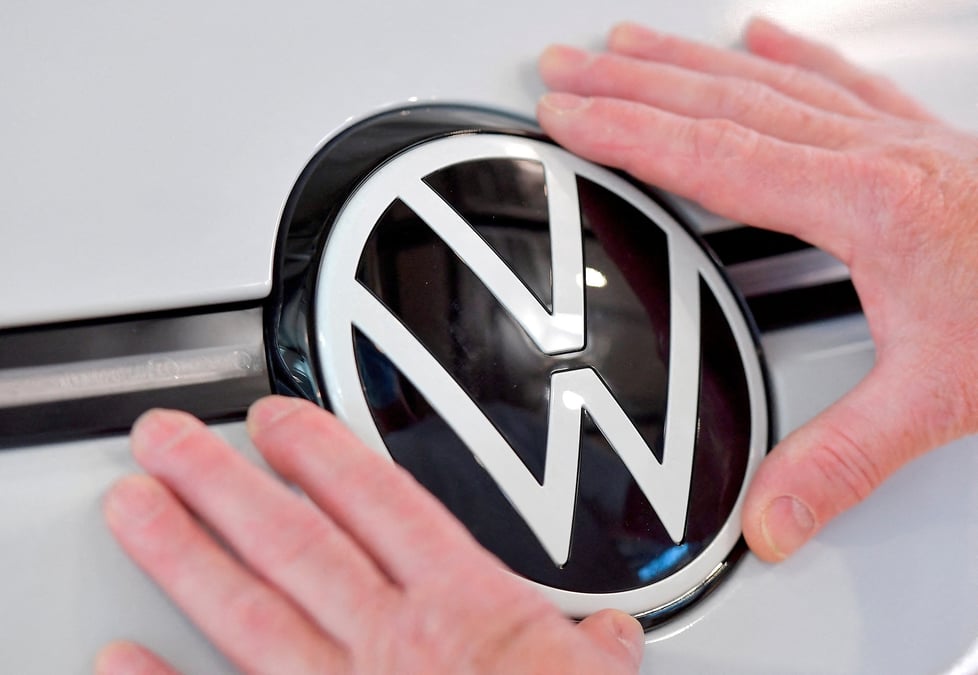 Photo d'archives: un technicien attache un panneau vw dans la chaine de montage de la voiture electrique id. 3 du constructeur automobile allemand volkswagen