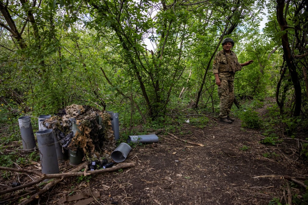 Un soldat ukrainien se tient pres de cartouches d'obus vides a la peripherie de chasiv yar, en ukraine