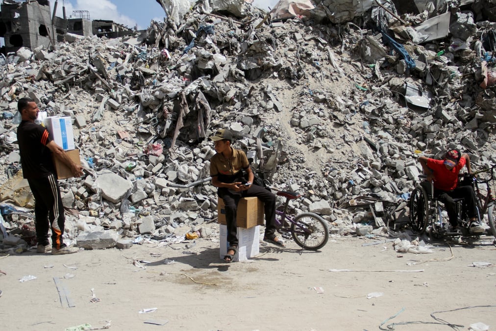 Un garcon est assis sur des boites alors que les palestiniens se rassemblent pour obtenir de l'aide a jabalia, dans le nord de la bande de gaza