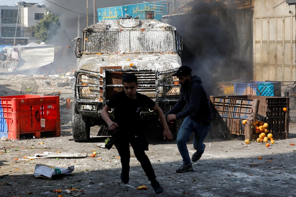 Des palestiniens courent alors qu'ils affrontent les forces israeliennes en cisjordanie occupee par israel