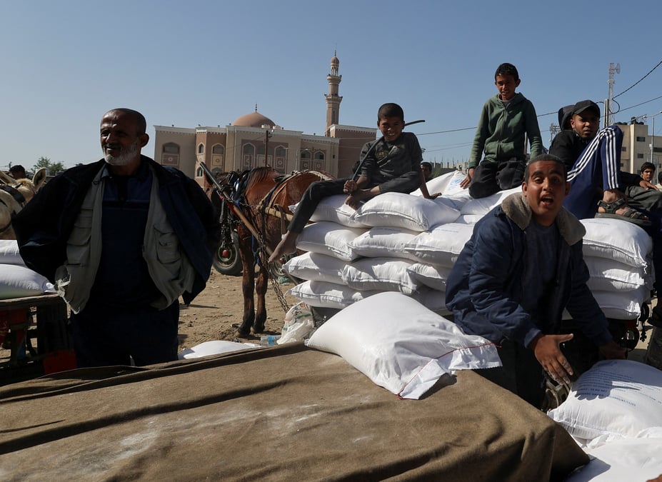 Des palestiniens se rassemblent pour recevoir de la farine distribuee par l'unrwa