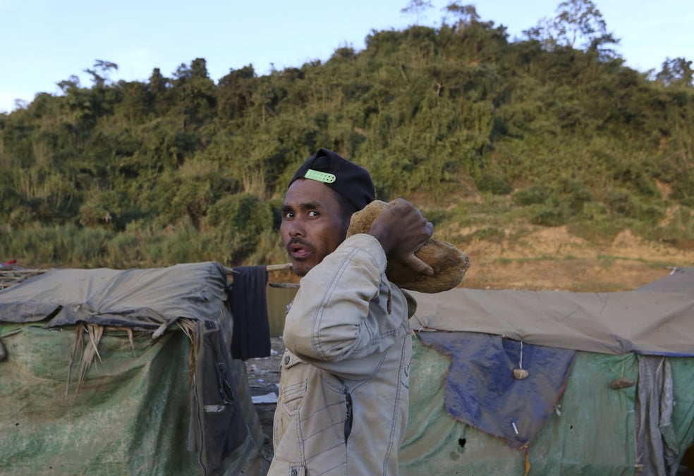 Un mineur au cote d'un mine de jade a hpakant, au myanmar