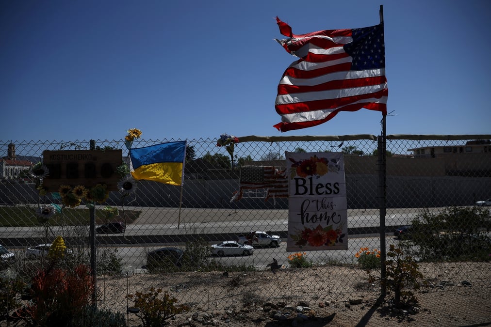 Un drapeau des etats-unis et un drapeau de l'ukraine flottent au vent le long d'une cloture a l'exterieur de los angeles