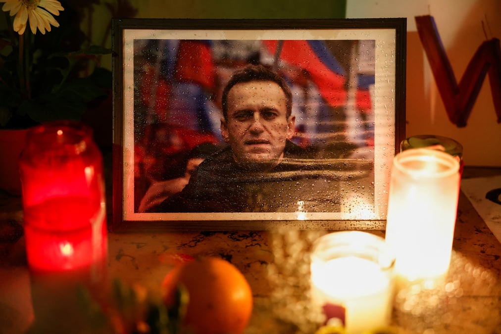 Des bougies brulent a cote d'une photo d'alexei navalny lors d'un evenement commemoratif a paris