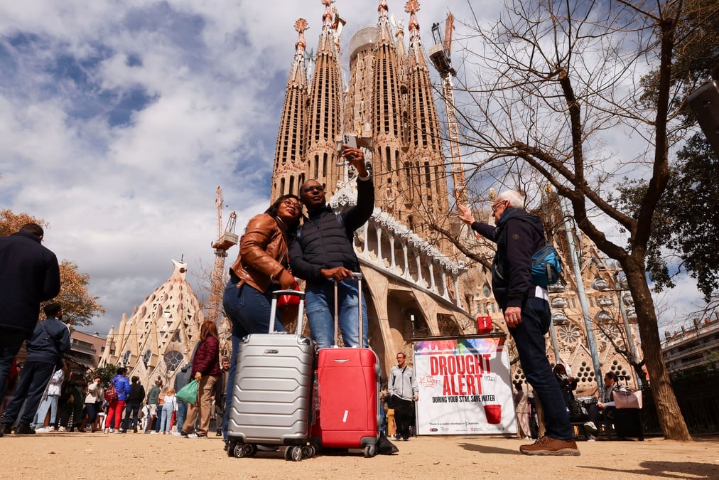 Des touristes prennent un selfie a cote de la basilique de la sagrada familia a barcelone