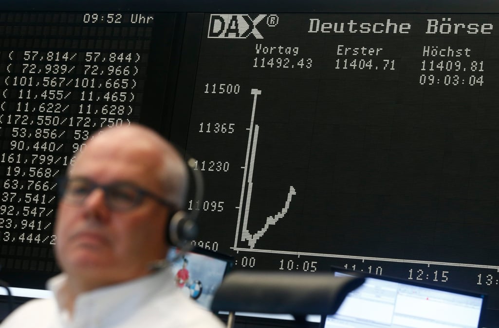 Un trader est assis devant le tableau du dax a son bureau a la bourse de francfort