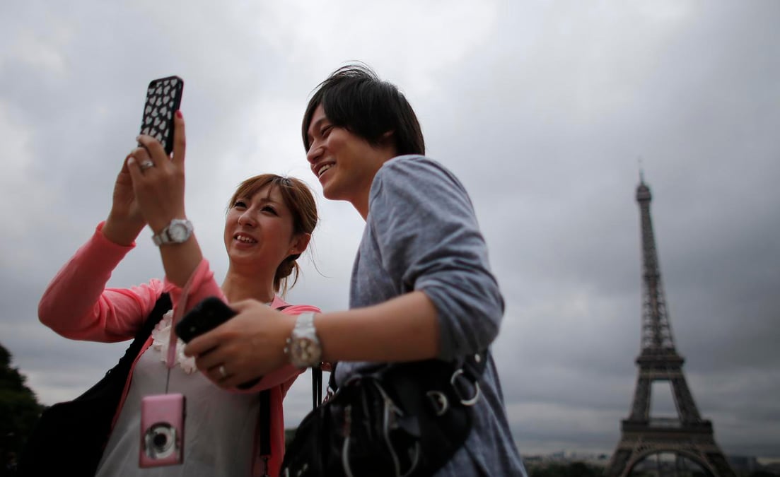 Touristes asiatiques à Paris devant la Tour Eiffel
