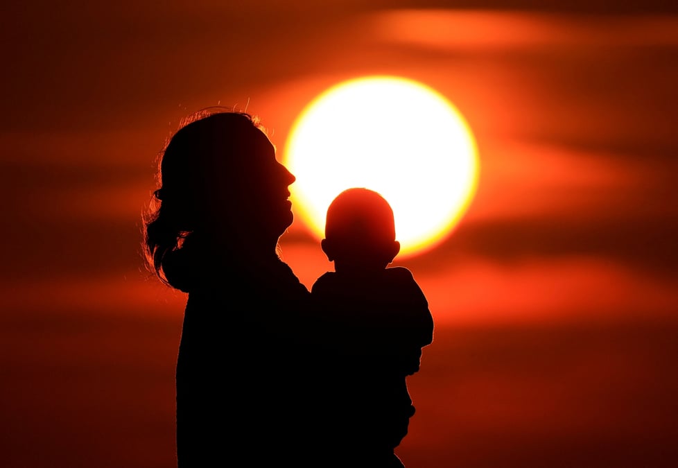 Une mere et son bebe profitent du coucher de soleil a calais