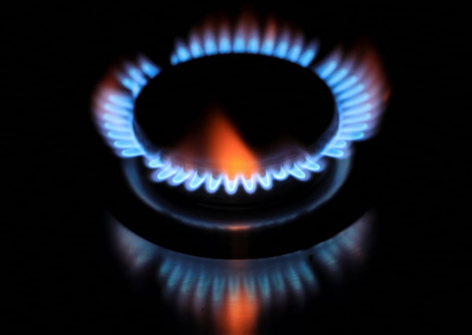 Les flammes d'un bruleur se refletent sur une plaque de cuisson